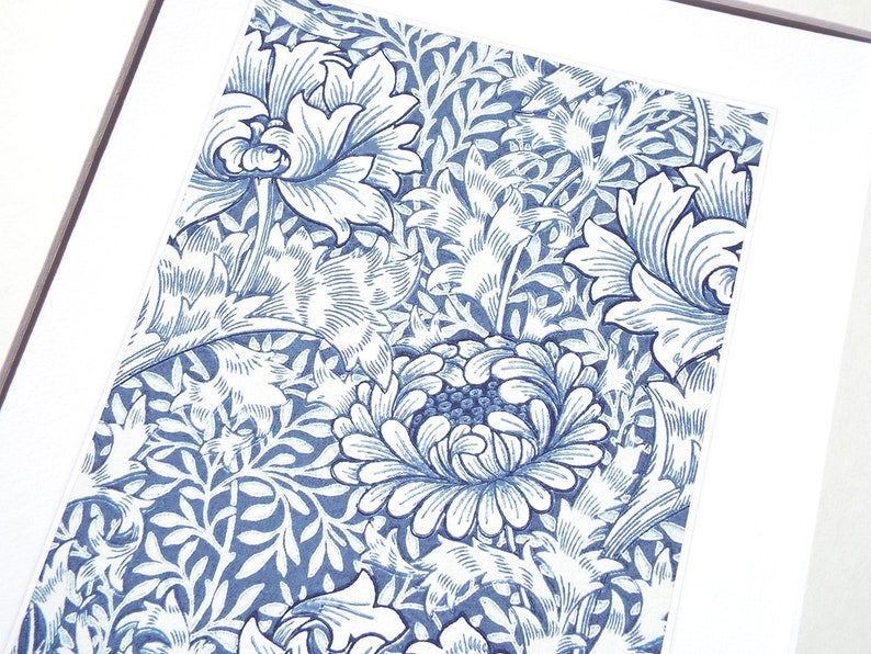 May include: A framed print featuring a detailed floral pattern in shades of blue and white. The design showcases stylized flowers and foliage, creating a classic and elegant aesthetic. The artwork is mounted on a white mat.