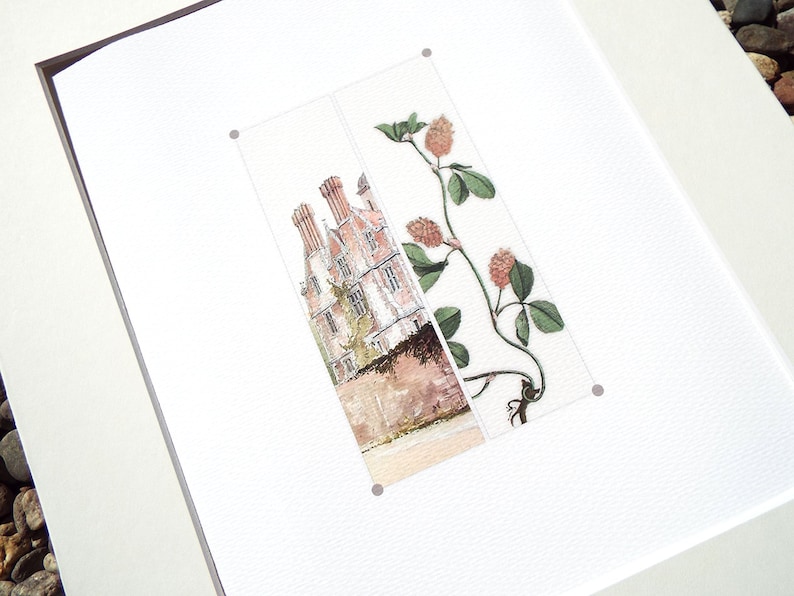 May include: A framed art print featuring a watercolor illustration. The artwork depicts a building with red brick and chimneys, alongside a botanical illustration of a plant with green leaves and reddish-brown seed heads.