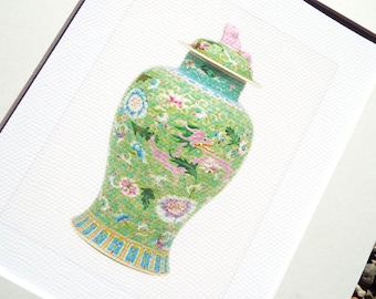 May include: A green and white porcelain vase with a pink lid and floral designs. The vase has a round body and a narrow neck.