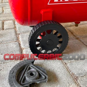 Puede incluir: Compresor de aire rojo con una rueda negra y un componente de rueda separado. El compresor tiene la palabra "Red" en letras blancas. El componente de la rueda separada es negro y tiene un centro triangular.