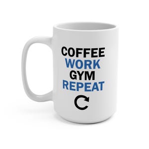 Puede incluir: Taza de cerámica blanca con un asa grande. La taza presenta las palabras "COFFEE WORK GYM REPEAT" en texto negro y azul, con una flecha circular negra debajo.