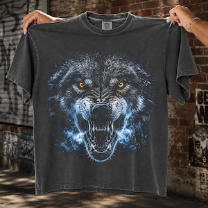 Ferocious wolf with glowing amber eyes, exposed fangs, and electric blue energy mist emerging from its mouth on black background, powerful halftone predator design for t-shirt sublimation print