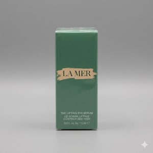 K&ouml;nnte beinhalten: Eine rechteckige gr&uuml;ne Schachtel von La Mer The Lifting Eye Serum. Die Vorderseite zeigt den Markennamen in goldener Schrift auf einem Pinselstrich-Hintergrund, mit Produktdetails wie 0,5 fl. oz. und 15 ml in Wei&szlig; unten aufgedruckt.