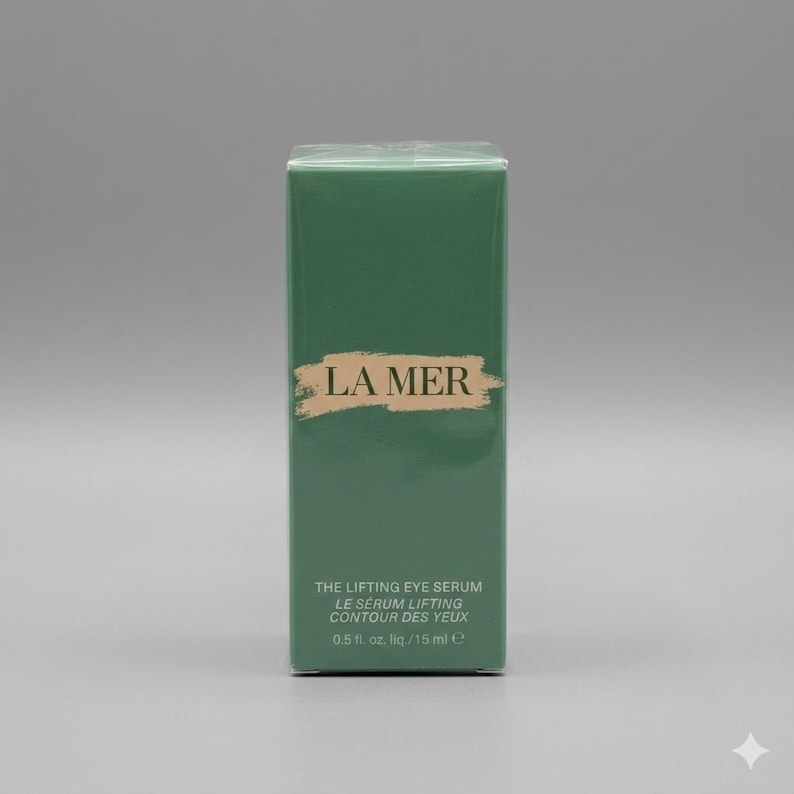 K&ouml;nnte beinhalten: Eine rechteckige gr&uuml;ne Schachtel von La Mer The Lifting Eye Serum. Die Vorderseite zeigt den Markennamen in goldener Schrift auf einem Pinselstrich-Hintergrund, mit Produktdetails wie 0,5 fl. oz. und 15 ml in Wei&szlig; unten aufgedruckt.