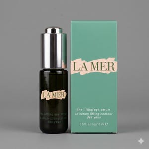 K&ouml;nnte beinhalten: Eine dunkle Glasflasche mit La Mer The Lifting Eye Serum und silbernem Tropfverschluss neben der rechteckigen hellgr&uuml;nen Pappschachtel. Die Schachtel zeigt den Schriftzug LA MER in Dunkelgr&uuml;n auf einem beigen Pinselstrich und 15 ml e.