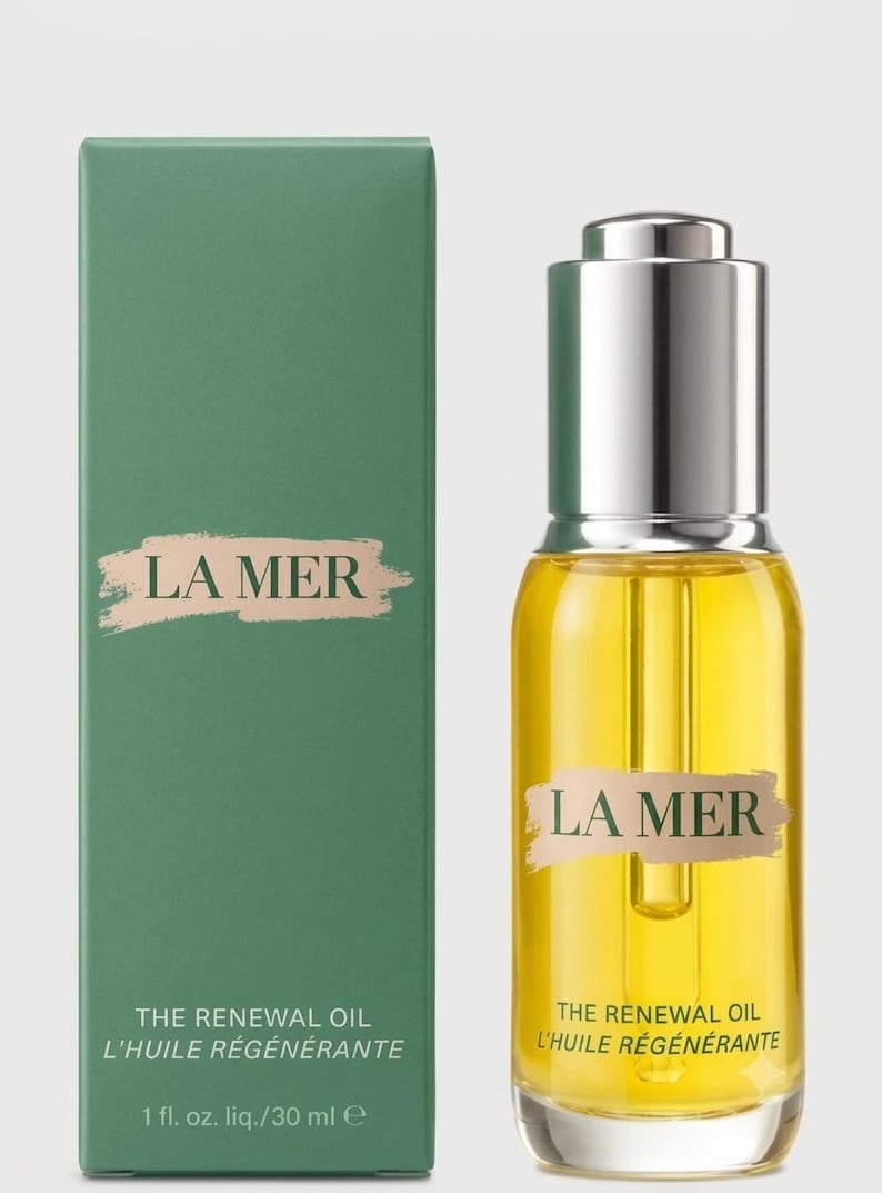 May include: A rectangular green box and a clear glass bottle of La Mer The Renewal Oil. The box features the text LA MER, THE RENEWAL OIL, L'HUILE R&Eacute;G&Eacute;N&Eacute;RANTE, and 1 fl. oz. liq./30 ml. The bottle has a silver dropper cap and yellow liquid.