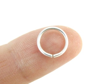 May include: A silver jump ring, a small metal ring used for connecting jewelry components.