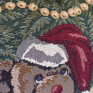 May include: A woven tapestry pillow cover featuring a brown bear wearing a red Santa hat with a white pom-pom and trim. The background is a dark green fabric with a pattern of light-colored circular ornaments arranged in a horizontal row.