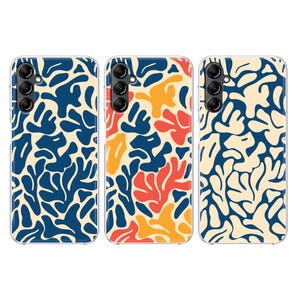 May include: Three phone cases with abstract designs. The cases feature a repeating pattern of navy blue, orange, and yellow shapes against a cream background. Each case has a camera array.