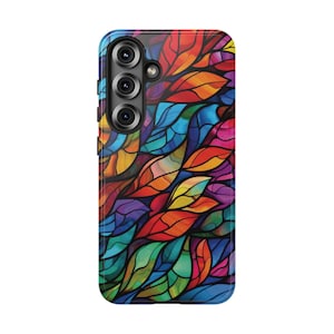 May include: A smartphone case featuring a colorful stained-glass design. The case has a glossy finish and a pattern of stylized leaves in shades of red, orange, yellow, green, blue, and purple. The phone case has a camera module with three lenses.