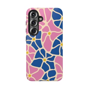 May include: A mobile phone case featuring a repeating pattern of stylized flowers in shades of pink and blue, separated by cream-colored outlines. Each flower has a small yellow center, and the design covers the entire back of the phone case.