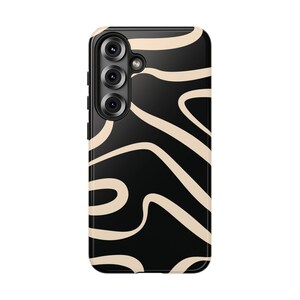 May include: Black smartphone case with a cream-colored abstract swirl design. The case has a glossy finish and a camera array on the upper left side. The design features flowing, curved lines.