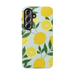 May include: A light blue smartphone case featuring a repeating pattern of bright yellow whole lemons, sliced lemon segments, and dark green leaves. The case includes a black camera module cutout positioned in the upper left corner of the back.