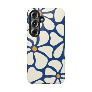 May include: A rectangular phone case featuring a repeating pattern of large, off-white, rounded flower petals against a deep blue background. Each flower has a small, solid orange circular center. The case includes a black camera lens cutout.