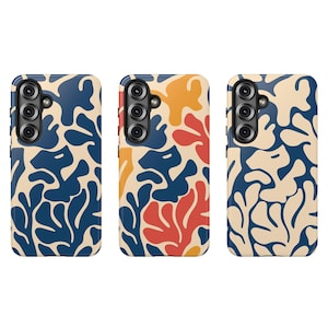 May include: Three phone cases with abstract designs. The cases feature a beige background with blue, orange, and red organic shapes. Each case has a black camera module.