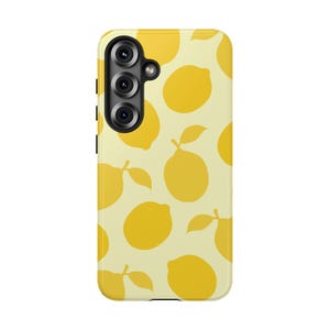 May include: A rectangular smartphone case featuring a repeating pattern of yellow lemons with green leaves on a pale cream background. The case has a vertical camera cutout on the upper left side containing three circular black camera lenses.
