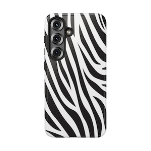 May include: A smartphone case with a black and white zebra stripe pattern. The case has a camera module with three lenses and a flash. The case is designed to protect the phone from scratches and damage.