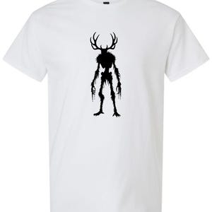 May include: White t-shirt featuring a black silhouette of a creature with antlers, a skeletal torso, and dripping limbs. The graphic is centered on the shirt, creating a striking contrast against the white fabric. This tee is perfect for fans of fantasy and horror.
