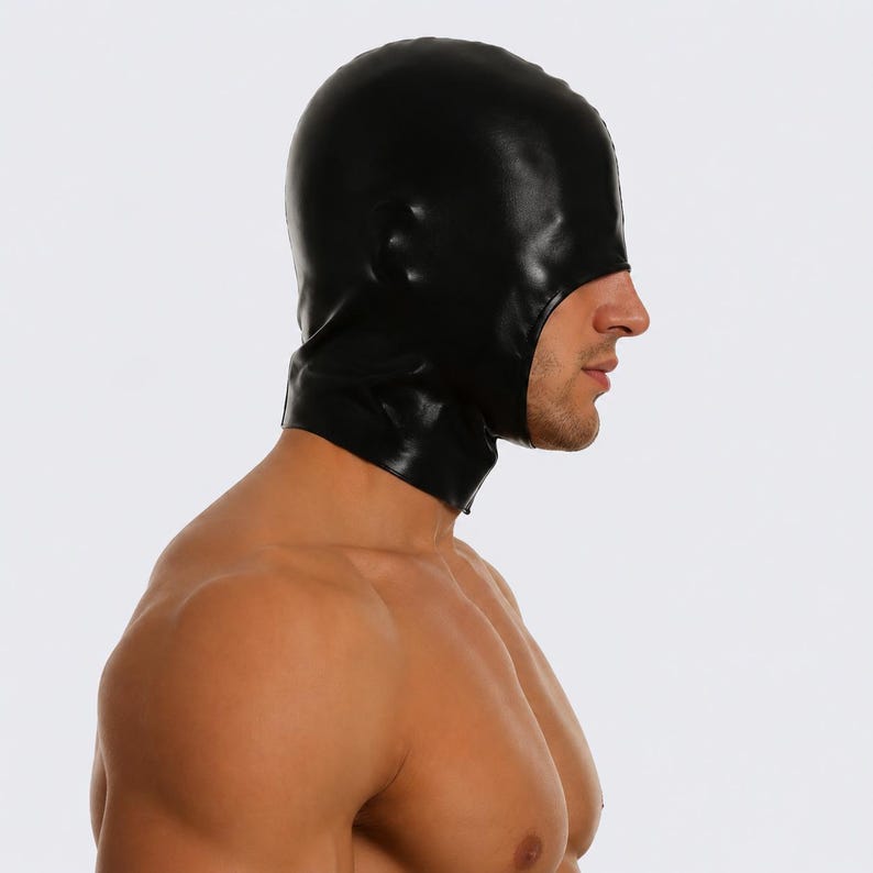 May include: Black hood with a smooth, shiny surface. The hood covers the head and neck, with an opening for the face. The material appears to be a form-fitting latex or similar material. The hood is designed for a specific purpose.