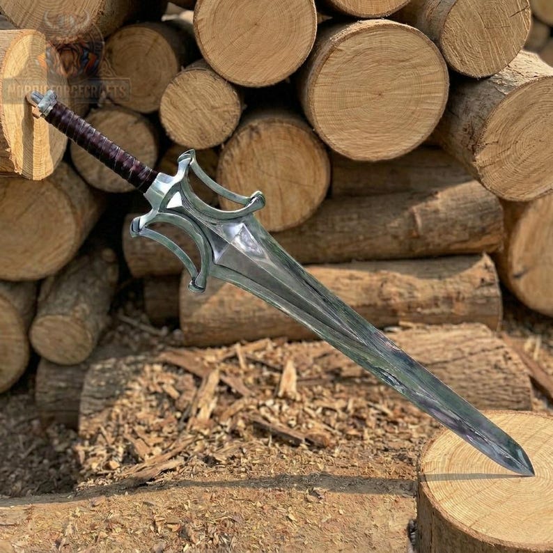 May include: A silver sword with a decorative hilt and a long, pointed blade. The handle is wrapped in dark brown material. The sword is displayed against a backdrop of stacked logs and wood shavings.