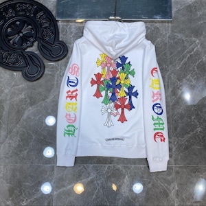 Peut inclure: Sweat à capuche blanc avec un motif de croix colorées sur le dos et les manches. Les manches présentent le mot "Chrome Hearts" en lettres arc-en-ciel. Le sweat à capuche a une capuche à cordon et une poche kangourou.