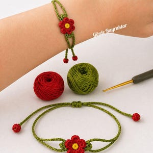 May include: Handmade crochet bracelet featuring a red flower with a yellow center and green leaves. The bracelet is green and has red accents. The image also shows a ball of red yarn, a ball of green yarn, and a crochet hook. The text "Gözde Bayraktar" is visible.