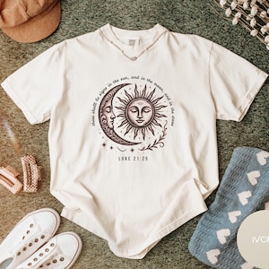 Camiseta cristiana Sol y Luna de Comfort Colors, camiseta celestial con versículo bíblico Lucas 21:25, camiseta espiritual estilo boho retro, ropa con temática religiosa.