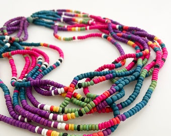 May include: A multi-strand necklace featuring small, colorful beads in shades of blue, pink, purple, green, yellow, and white. The necklace has a layered design, with each strand displaying a gradient of colors. The beads are strung together, creating a vibrant and eye-catching accessory.