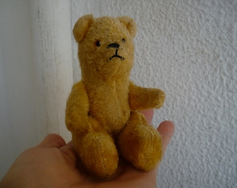 antique,5&#39;&#39; miniature,bear,jointed limbs,glass eyes,with small leather satchel or backpack.
