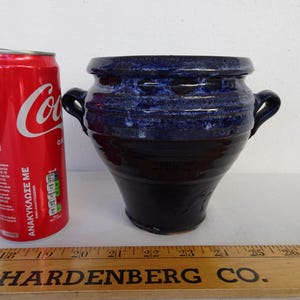 May include: A set of three ceramic mugs with a speckled, matte finish. The mugs are in shades of cream, light gray, and dark gray. Each mug has a simple, minimalist design and a rounded handle.