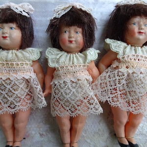 set di 5 bambole Petitcollin vintage, rappresentanti i Dionne Quintuplets, ancora sulla cartolina originale.