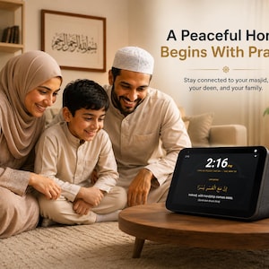 Könnte beinhalten: Ein schwarzes Smart-Display auf einem Holztisch zeigt die Uhrzeit 14:16 Uhr und den Text A Peaceful Home Begins With Prayer, Stay connected to your masjid, your deen, and your family, sowie Indeed, with hardship comes ease.