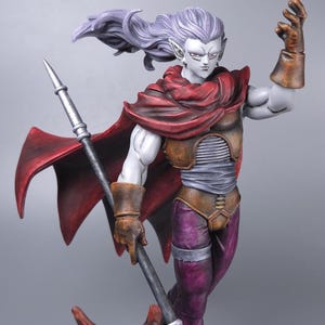 May include: A detailed figurine of a character with pale skin, long flowing purple hair, and pointed ears. The figure wears a red cape, brown armor, and purple pants, holding a scythe-like weapon. The base is a textured, reddish-brown.