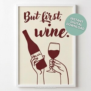 Pode incluir: Impressão artística emoldurada com o texto "But first, wine." A imagem apresenta uma garrafa de vinho e uma taça de vinho, ambas em vermelho escuro, seguradas por mãos. Um círculo turquesa com "Instant Digital Download" está no canto superior direito.