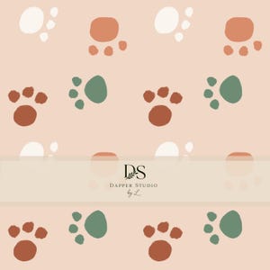 May include: A repeating pattern of paw prints in shades of terracotta, sage green, and off-white on a light peach background. A horizontal band across the center displays the black text DS DAPPER STUDIO by L with a small leaf graphic.