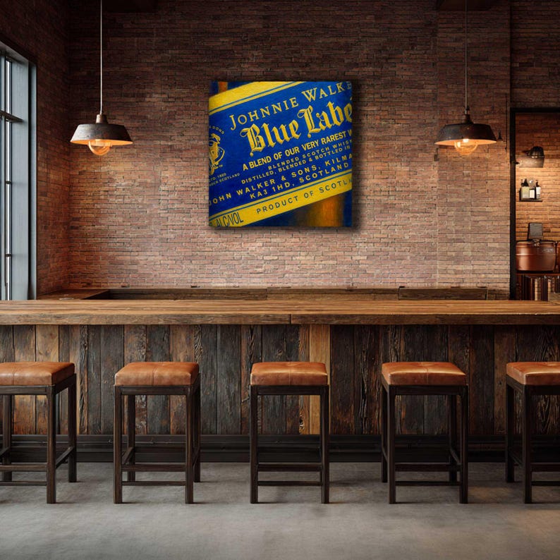 May include: A canvas print featuring the Johnnie Walker Blue Label logo in blue and yellow. The print is displayed above a wooden bar with leather-topped stools. The text on the print reads "A blend of our very rarest blended scotch whisky."