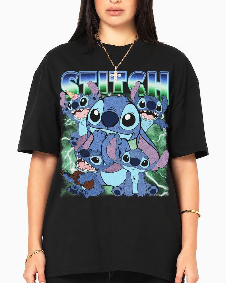 May include: A black short-sleeve t-shirt featuring a graphic print of the character Stitch in various poses. The word STITCH is printed in a blue and green gradient font at the top. The background of the graphic includes green lightning bolts.
