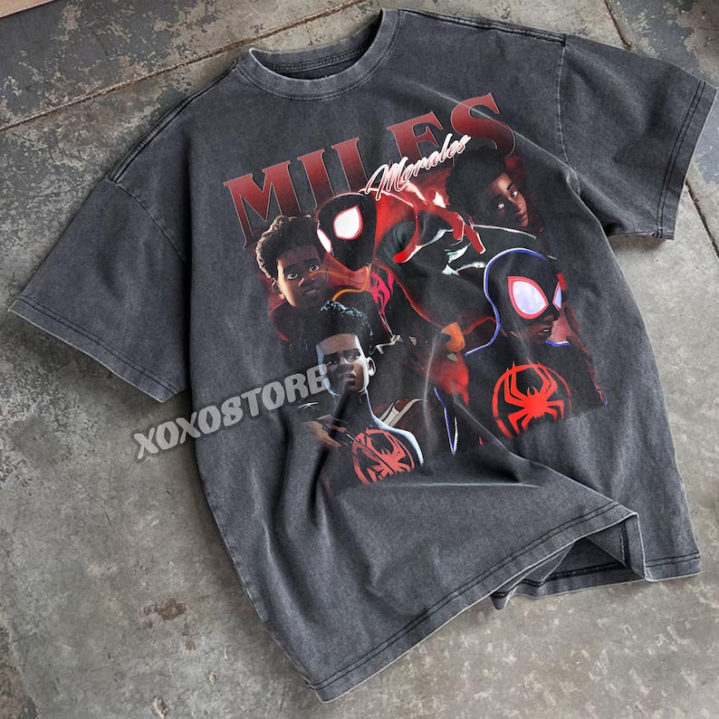 K&ouml;nnte beinhalten: Dunkelgraues T-Shirt mit einem Aufdruck von Miles Morales. Das Wort "MILES" ist rot gedruckt, mit "Morales" in Schreibschrift. Das T-Shirt hat einen Vintage-Look. Das Design zeigt mehrere Bilder der Figur.