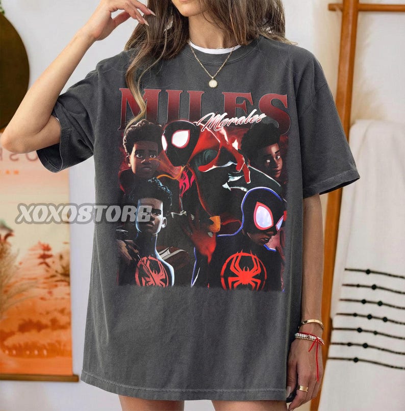 K&ouml;nnte beinhalten: Dunkelgraues T-Shirt mit einer Grafik von Miles Morales im Spider-Man-Anzug. Das Design enth&auml;lt den Text "MILES Morales" in Rot und Wei&szlig;. Das Shirt hat einen Vintage-Look.