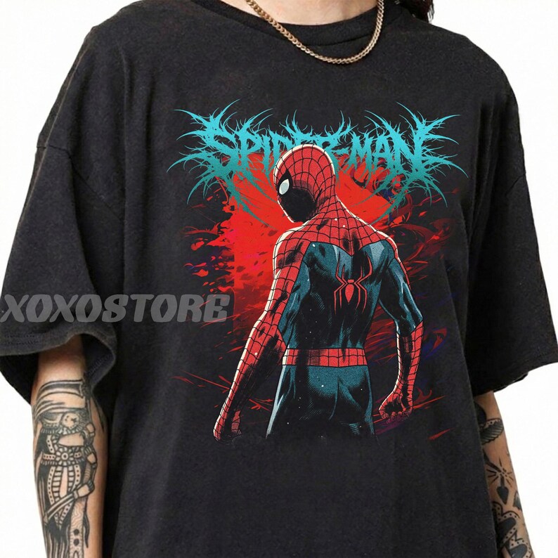 May include: Dark gray t-shirt featuring a graphic of Spider-Man from the back, with a red and blue suit. The design includes the text "SPIDER-MAN" in a stylized, blue font above the character. The shirt has the text "XOXOSTORE" on the left side.