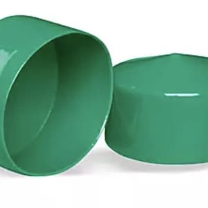 May include: Two smooth, cylindrical green plastic end caps. One cap is positioned on its side, revealing its hollow interior, while the other cap is placed upright, showing its solid, flat top surface. Both items feature a glossy finish.