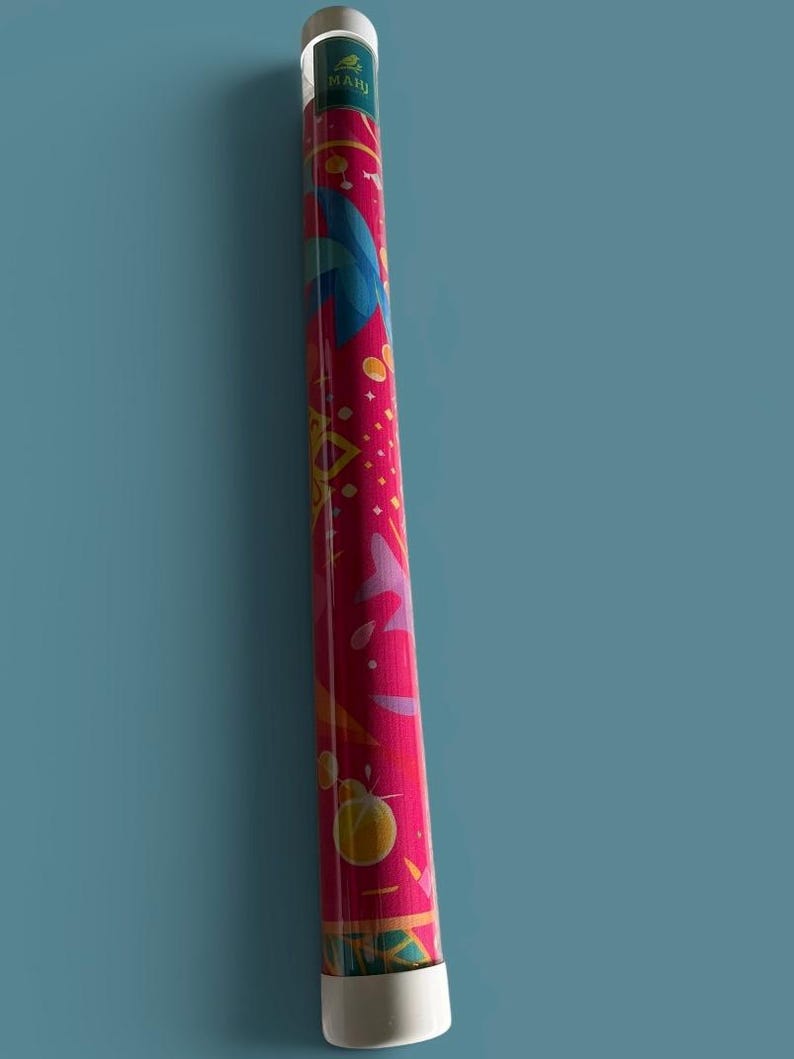 May include: A cylindrical storage tube with a vibrant magenta background featuring a colorful graphic pattern of blue, yellow, and pink shapes. The top and bottom caps are white, and a small green label with the text MAHI is visible near the top.