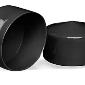 May include: Two cylindrical black end caps with a smooth, glossy finish. One cap is positioned upright to show its flat top surface, while the other is tilted on its side to reveal the hollow interior and the circular opening of the component.