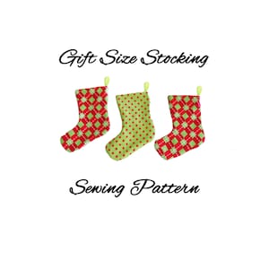 Pode incluir: Três meias de Natal em fila, cada uma com um padrão diferente. As meias são vermelhas e verdes, com padrões que incluem bolinhas e losangos. O texto "Gift Size Stocking Sewing Pattern" está acima e abaixo das meias.