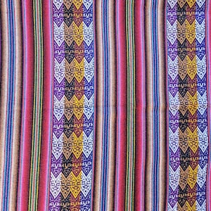 Peut inclure: Un textile coloré avec des rayures verticales et des motifs géométriques. Le design présente des bandes alternées de rouge, marron et bleu, avec des motifs complexes de losanges et de zigzags en jaune, violet et blanc. Le tissu a une texture tissée.