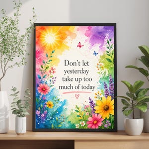 May include: A framed wall art print featuring a watercolor background with a bright yellow sun, colorful flowers, and two small butterflies. The text reads, "Don't let yesterday take up too much of today," with a small red heart symbol below the text.