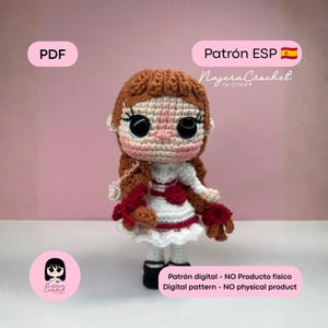 Puede incluir: Una muñeca de ganchillo con pelo castaño rojizo, grandes ojos negros y mejillas rosadas, vestida con un vestido blanco con detalles rojos y una rosa. La imagen incluye los textos: PDF, Patrón ESP, NajeraCrochet by Grace y Patrón digital - NO Producto físico.