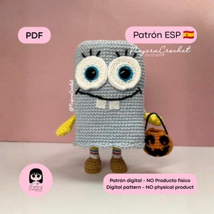 May include: A light blue crochet figure with large white eyes, blue pupils, and two white teeth. It has yellow arms, striped socks, and brown shoes. The figure holds a small orange jack-o'-lantern bucket with a black handle and face.