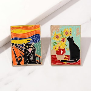 May include: Two rectangular enamel pins. One features a black cat in a parody of Edvard Munch's "The Scream" painting. The other pin depicts a black cat with sunflowers in a vase, inspired by Van Gogh's work. Both pins have gold-colored borders.