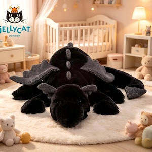 May include: A large, black plush dragon toy with grey wings and details, resting on a cream rug. The dragon has a soft, cuddly appearance, with a detailed head and tail. The image also includes other plush toys and nursery furniture.